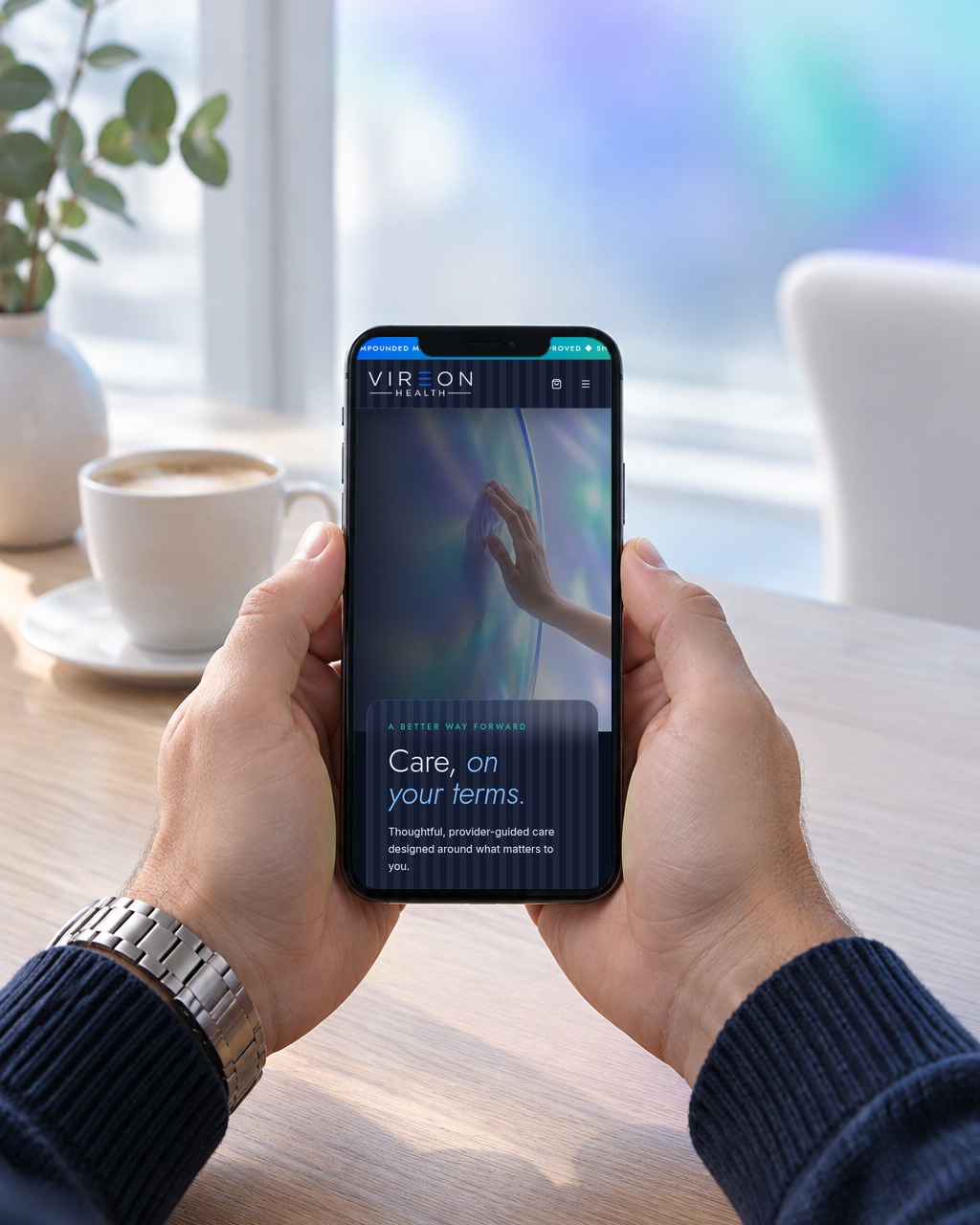 Hands holding a phone showing the Vireon Health website
